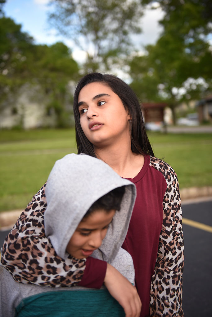 Narjes Al Hraishawi, 14, holds her brother Alhasan, 11